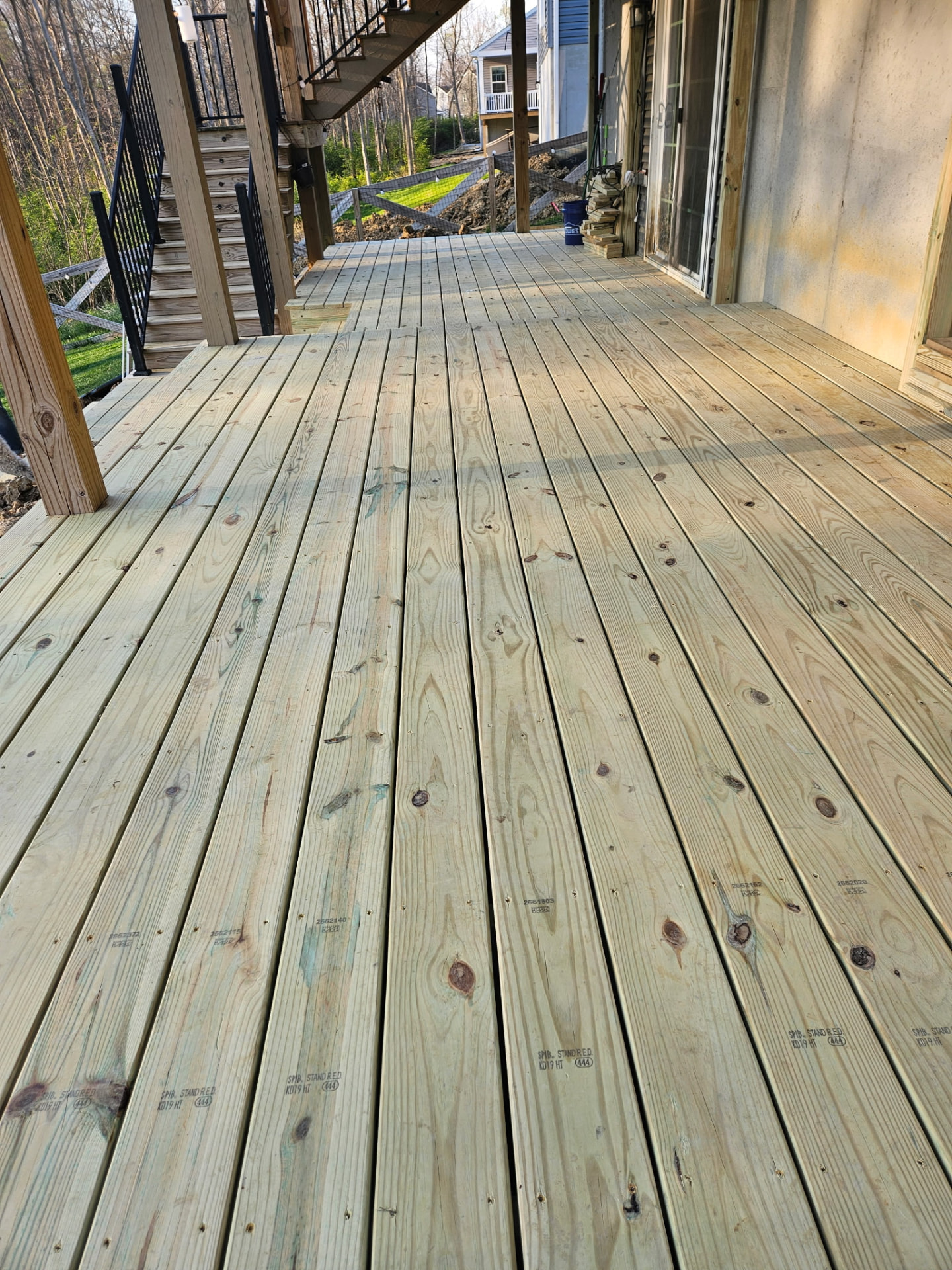 Finished pressure-treated deck boards running along the back of a home